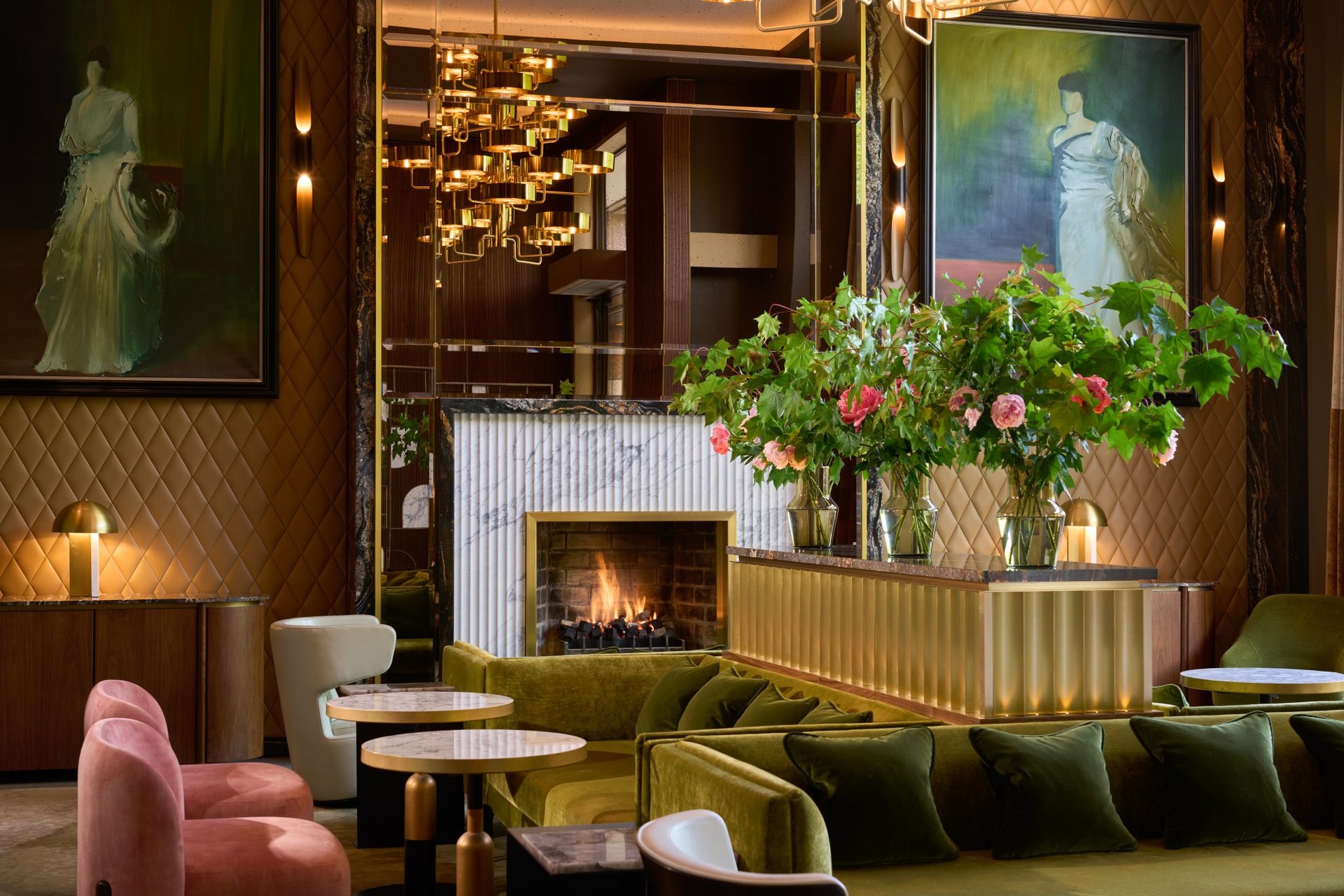 The lobby of The Fitzwilliam: a fire in a marble surround, velvet sofas, flowers and portraits